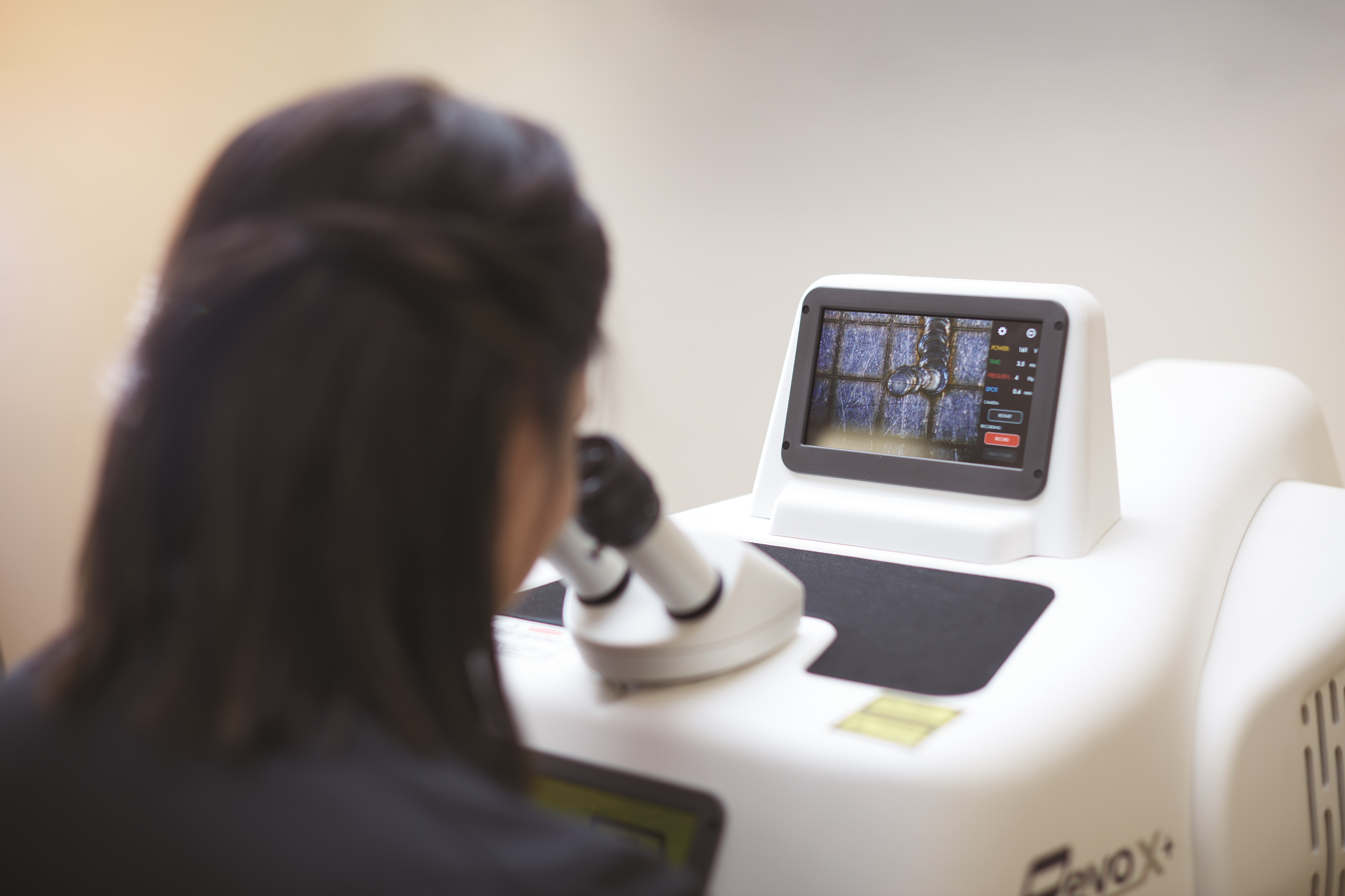 Gemologist inspecting a gem under a microscope.